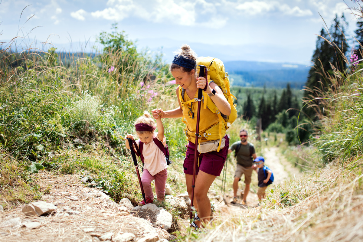 a woman and a child hiking on a trail