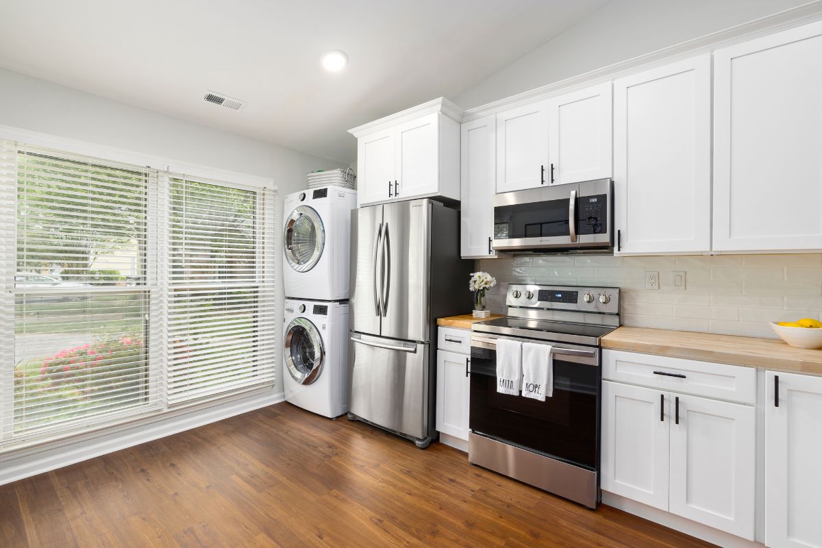 kitchen with fridge, oven, and stack washer and dryer